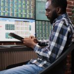 Investment company employee doing financial analysis having clipboard with capital documentation.